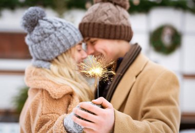Romantik genç çift Kış Günü 'nde Sparkler' ı kucaklıyor ve kucaklıyor