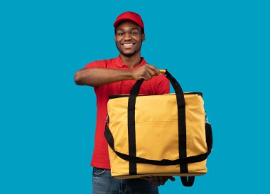 Afrikalı Amerikalı teslimatçı termo çantayla poz veriyor.