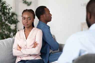 Üzgün Afrikalı Amerikalı eşler Evlilik Terapisinde sırt sırta oturuyorlar