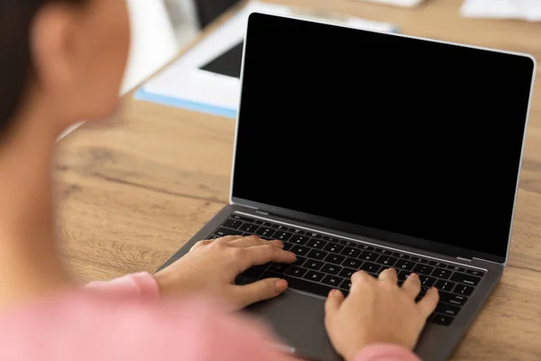 Lady werkt op laptop met leeg zwart scherm voor mockup — Stockfoto