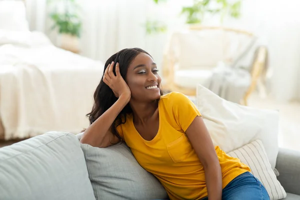 Junge Afroamerikanerin genießt faules Wochenende zu Hause, Chillen auf der Couch im Wohnzimmer — Stockfoto