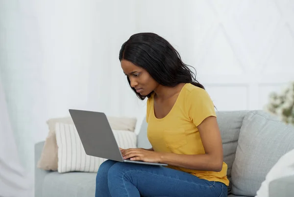 Studente nero pensieroso che ha difficoltà a superare l'esame o fare attività online sul computer portatile a casa — Foto Stock