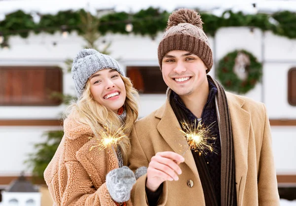 Hermosa pareja joven con chispas en las manos posando en el día de invierno al aire libre —  Fotos de Stock