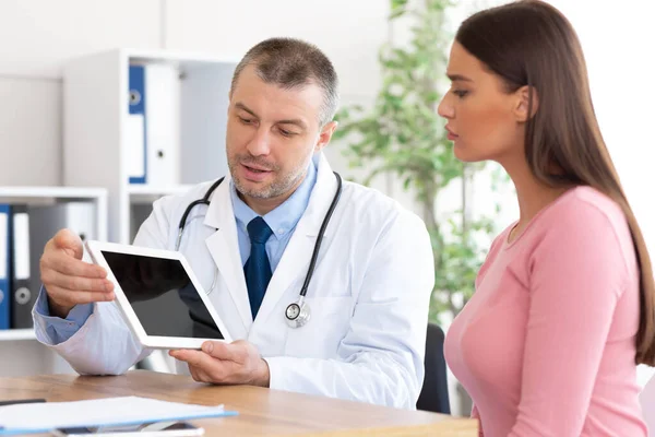 Dospělý lékař ukazující tabletu pacienta s černou prázdnou obrazovkou — Stock fotografie