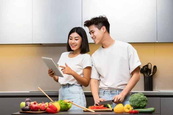 Married Korean Couple With Tablet Browsing Recipes In Modern Kitchen — Stock Photo, Image