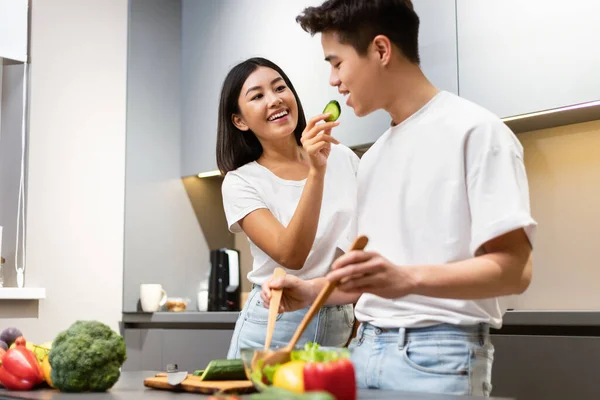 Japonais couple dégustation de nourriture tout en cuisinant dîner ensemble dans la cuisine — Photo