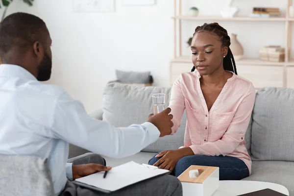 Psychotherapeut troostende verstoorde Afrikaanse Amerikaanse dame tijdens therapiesessie op kantoor — Stockfoto