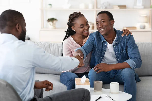 Dankbare schwarze Ehepartner schütteln nach erfolgreicher Ehetherapie dem Berater die Hand — Stockfoto