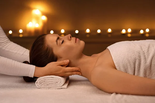Oigenkännlig terapeut masserar sovande kvinna hals, sidovy — Stockfoto