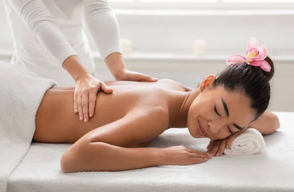 Zrelaksowana Azjatka leczona przez profesjonalnego masażystę w salonie — Zdjęcie stockowe