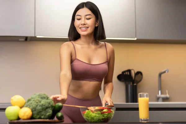 Passar asiatisk kvinna matlagning sallad bantning och bantning i köket — Stockfoto