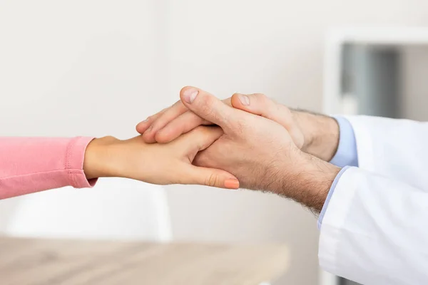 Крупним планом чоловічий лікар тримає руки пацієнток — стокове фото