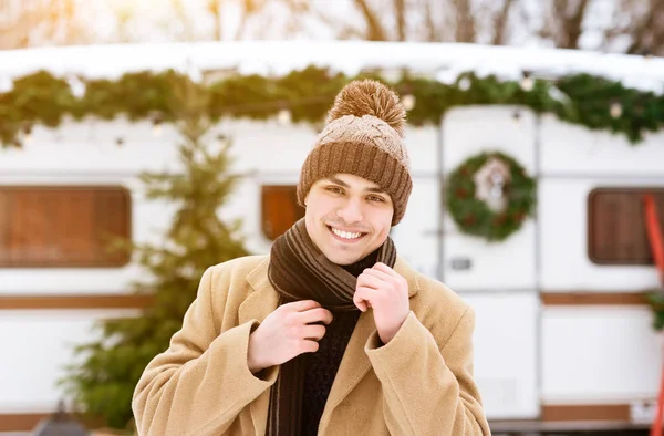 Guapo joven posando al aire libre cerca de la caravana moderna en el día de invierno —  Fotos de Stock