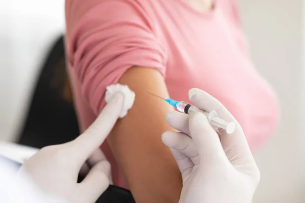 Mannelijke arts doet vaccinatie bij jonge vrouw — Stockfoto