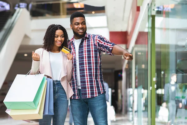Een paar over winkelen. Positieve zwarte echtgenoten die samen aankopen doen in het warenhuis — Stockfoto