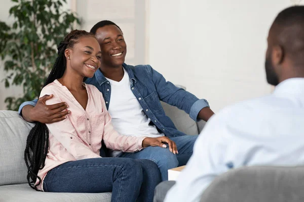 Mariage Se réconcilier. Heureux conjoints africains assis au bureau des conseillers après une thérapie réussie — Photo