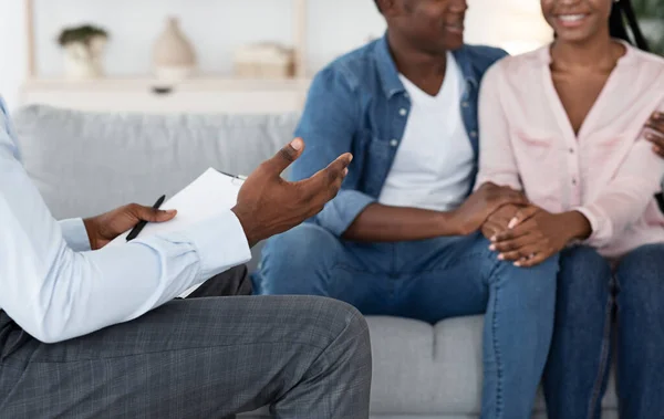 Eheberatung. Unerkennbarer schwarzer Berater im Gespräch mit glücklichem schwarzen Paar im Büro — Stockfoto