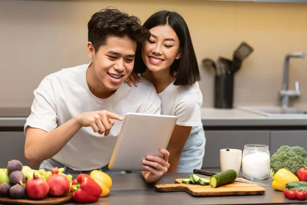 Korean Husband And Wife Cooking Using Digital Tablet In Kitchen — Stock Photo, Image