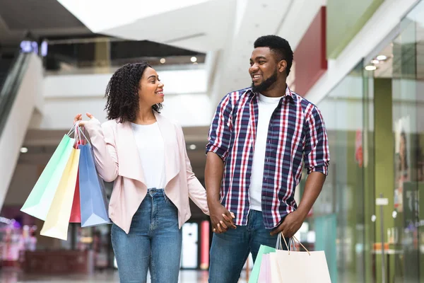 Szczęśliwa czarna para zakupoholiczka spacerująca po domu towarowym, ciesząca się robieniem zakupów razem — Zdjęcie stockowe