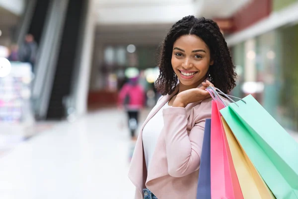Porträtt av vacker svart kvinna poserar med shoppingväskor i varuhuset — Stockfoto