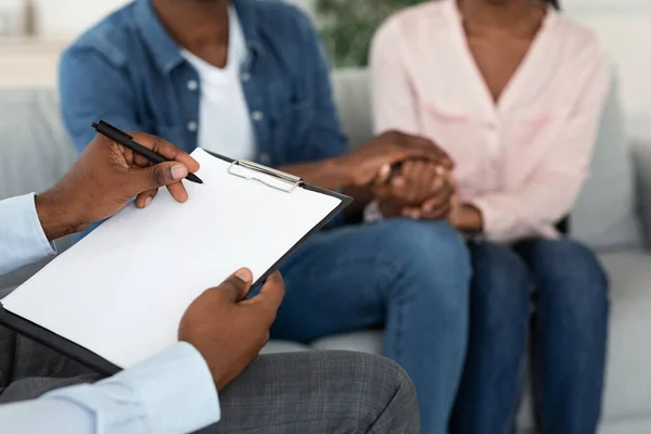 Huwelijksconsulent neemt notities tijdens therapiesessie met Afro-Amerikaanse echtgenoten — Stockfoto