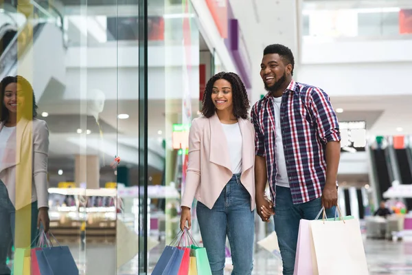 Černošky Shopaholic pár dělat nákupy v obchoďáku spolu, těší sezónní nakupování — Stock fotografie
