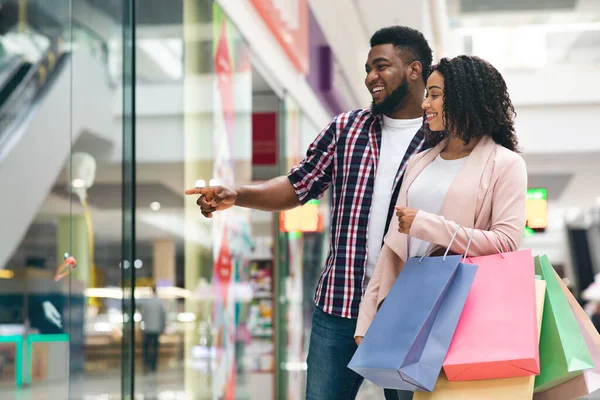 Koncepcja konsumencka. Szczęśliwy czarny małżonkowie zakupy razem w domu towarowym — Zdjęcie stockowe