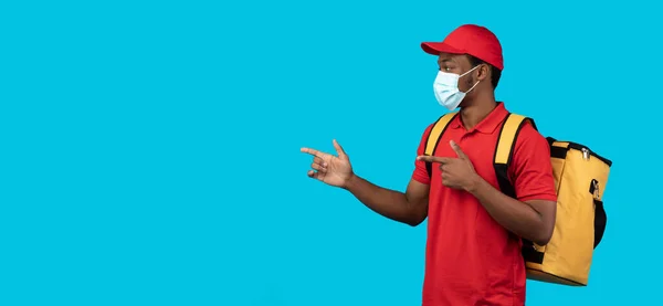 Afrikansk amerikansk leverans kille i medicinsk mask pekar bort — Stockfoto