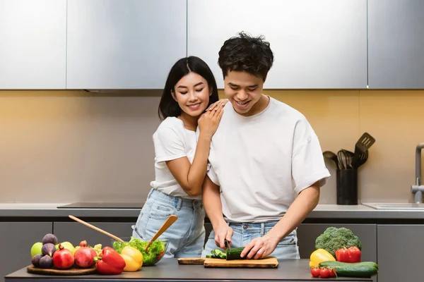 Aimant asiatique femme embrasser mari tout en cuisinant ensemble dans cuisine — Photo