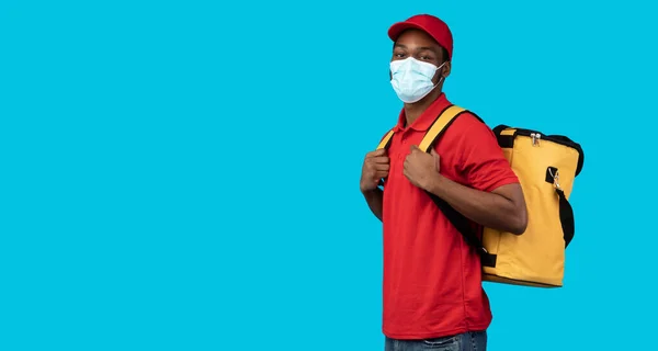 Hombre de entrega afroamericano en máscara protectora con bolso termo —  Fotos de Stock