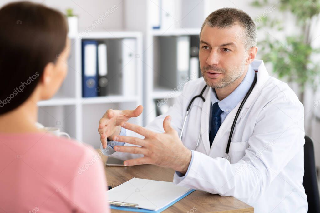 Middle aged experienced doctor talking to his patient