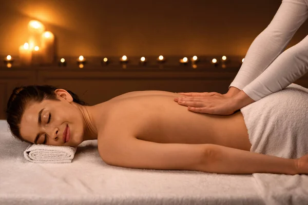 Tranquila jovencita disfrutando de un masaje de cuerpo completo — Foto de Stock