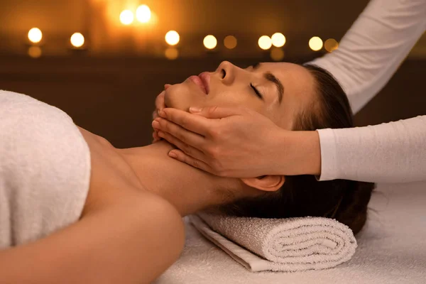 Relaxado jovem mulher recebendo levantamento massagem no moderno spa de luxo — Fotografia de Stock