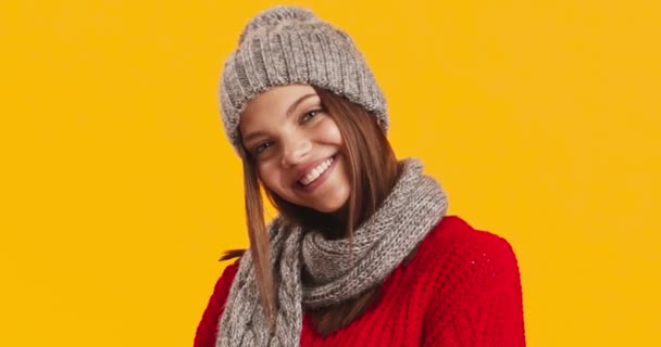 Studio ritratto di donna sorridente in maglia cappello e sciarpa, posa su sfondo giallo — Video Stock