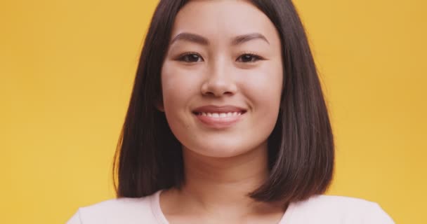 Játékos boldog ázsiai nő pislogó szem, nézi kamera fogas mosoly, kacsintás és flörtölés — Stock videók