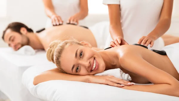 Mulher feliz recebendo massagem de pedra em casais Spa Procedimento interior — Fotografia de Stock