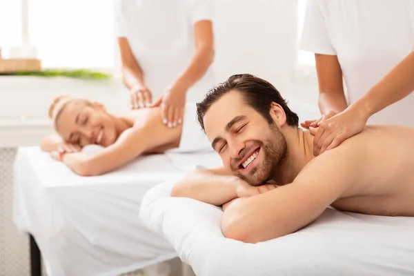 Esposo y esposa disfrutando de relajantes parejas masaje en el salón de spa —  Fotos de Stock