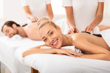 Kocasıyla kaplıcada taş masajı yaptıran kadın.