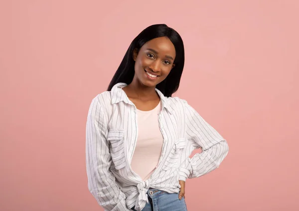 Portret van gelukkig zwart vrouw glimlachen en kijken naar camera op roze studio achtergrond — Stockfoto