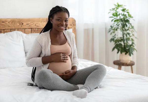 Konsep Persalinan. Happy Expectant Black Lady Posing On Bed At Home — Stok Foto