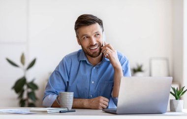 Mobil İletişim. Ofiste cep telefonuyla konuşan yakışıklı erkek girişimci.