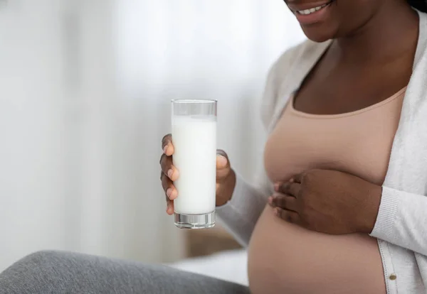 Потреби харчування під час вагітності. Чорна вагітна жінка тримає в руках молочне скло — стокове фото