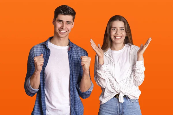 Feliz jovem casal se alegra com a sorte e ter grande chance e olha para a câmera, mulher bate palmas com as mãos — Fotografia de Stock