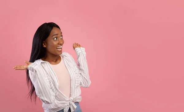 Jovem mulher negra excitada olhando para o espaço vazio no fundo do estúdio rosa, design de banner — Fotografia de Stock