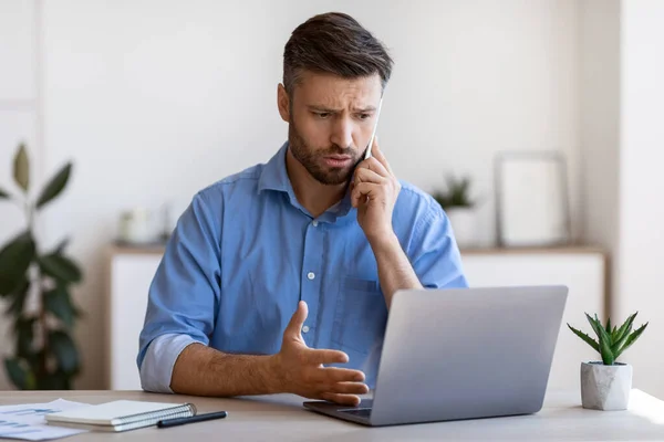 Erkek girişimci iş yerinde bilgisayarla sorun yaşıyor, müşteri desteği ile konuşuyor — Stok fotoğraf