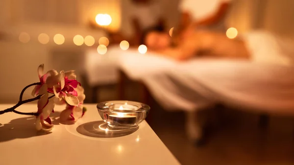 Paar erhält Massage Indoor, Spa-Komposition mit Kerze und Blumen — Stockfoto