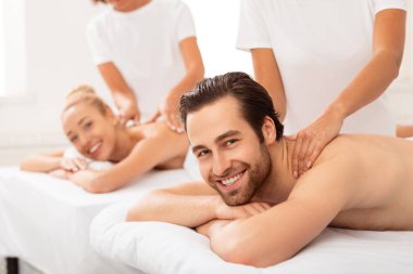 Neşeli bir çift boyun masajı yaptırıyor Spa 'da birlikte yatıyorlar