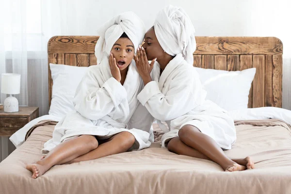 Mulheres americanas africanas bonitas que compartilham segredos, interior da casa — Fotografia de Stock