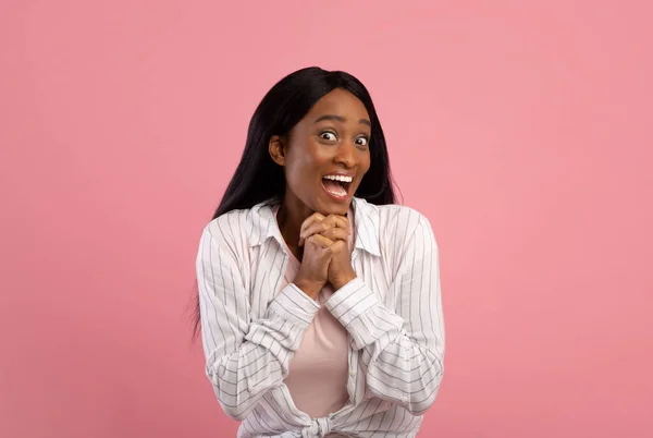 Красива молода чорна жінка виражає хвилювання або сюрприз на рожевому студійному фоні — стокове фото