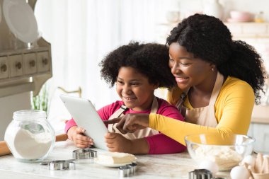 Mutlu Siyah Anne ve Küçük Kız Mutfakta Dijital Masayı Birlikte Kullanıyor
